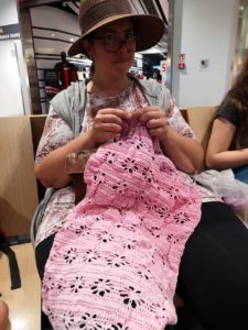 Pam aka Supernova Crochet at Bologna Airport crocheting a Painted Daisies wrap before a flight